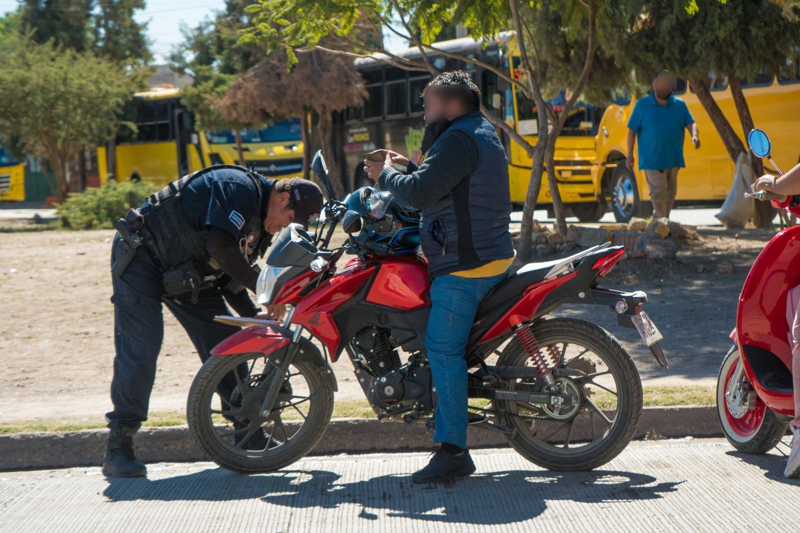 Fotografía de un policia inspeccionando una motocicleta